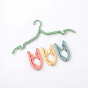 Cintre vert déplié et trois exemples pliés de couleur pastel sur fond blanc