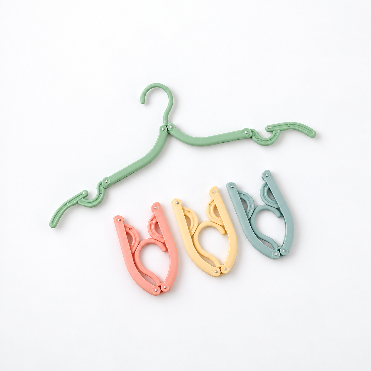 Cintre vert déplié et trois exemples pliés de couleur pastel sur fond blanc