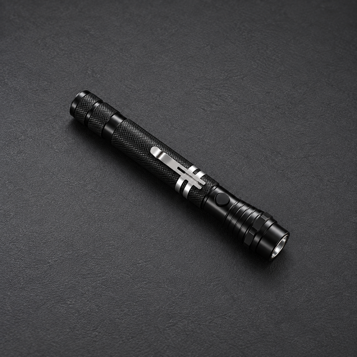 Lampe aimantée télescopique noire, repliée avec clip, sur fond graphite