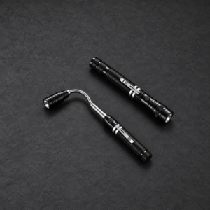 Deux vues de la même lampe aimantée télescopique noire, repliée et déployée avec col flexible et clip de ceinture, sur fond graphite