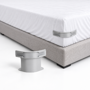 Maintien de draps gris présenté seul et installé au coin d'un matelas recouvert d'un drap blanc