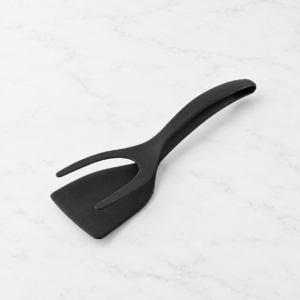 Spatule pince multifonction noire avec palette et fourche à deux branches sur fond blanc